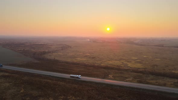 Aerial View of Semitruck with Cargo Trailer Driving on Highway Hauling Goods in Evening