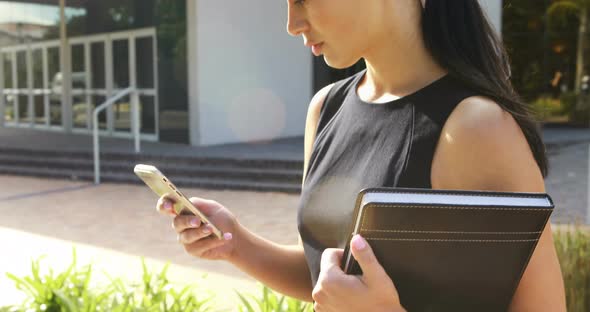 Business executive using mobile phone outside office building 4k