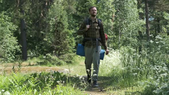 A tourist walks along the forest road	