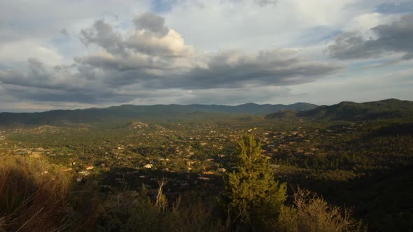 Storm clouds gather over Prescott homes in the mountains during sunset.