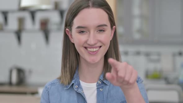 Portrait of Playful Young Woman Pointing at the Camera