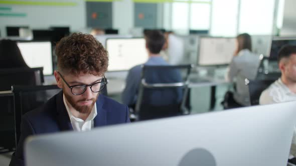 Portrait of Young Entrepreneur in Open Space Office Working on Decktop Computer