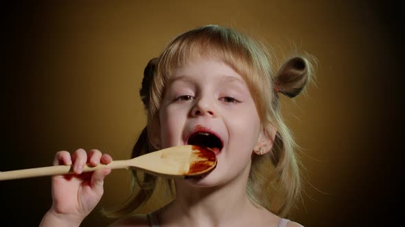 Playful Teen Child Kid Girl Eating Licking Melted Chocolate Sweet Candy Syrup From Wooden Spoon