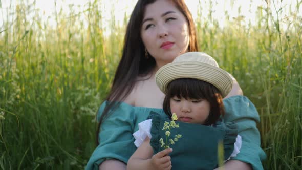 Koreans Family Mother and Daughter in Green Dresses Sitting in the Long Grass