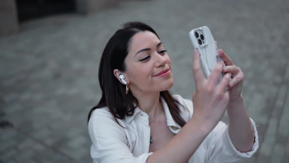 Pretty brunette woman in headphones making photo