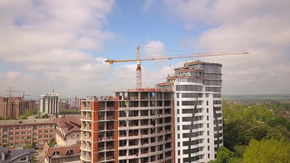 High industrial tower crane at construction site of new residential building.