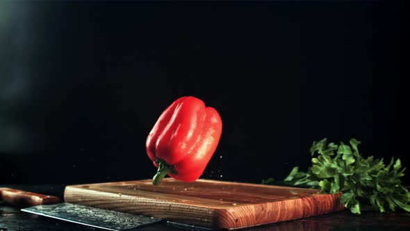 Sweet Peppers Fall on a Wooden Cutting Board