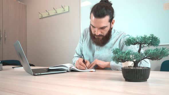 Footage of office worker man making notes in his daily agenda