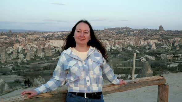 Smiling Woman Standing at View Point Above Majestic Valley in Cappadocia