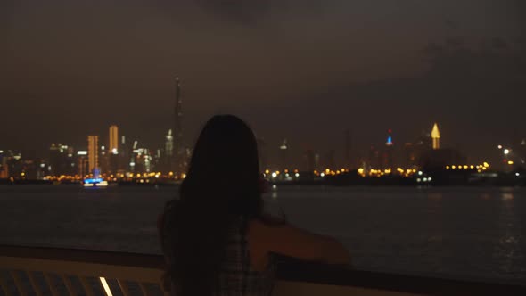 Woman Watching Dubai Skyscrapers at Night