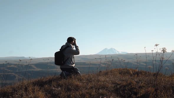 Man Makes a Photo in the Mountains