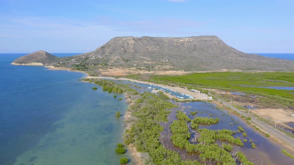 Aerial panorama shot of blue Atlantic Ocean,growing mangroves on shoreline and giant mountain in bac
