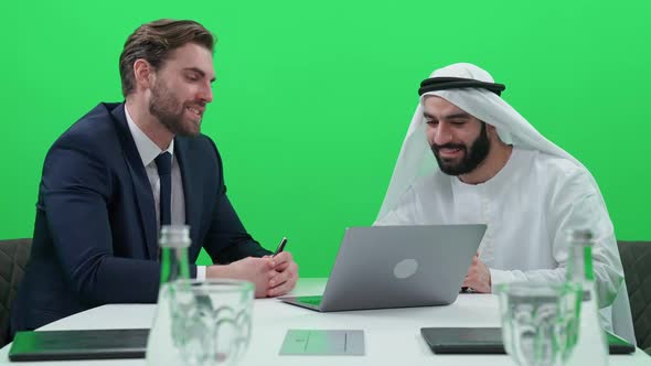 Business Meeting Man Uses a Laptop and Communicate with a Arab Business Partner in a White Kandura