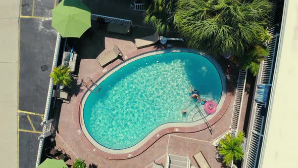 Top View of Children and Adults Swimming in the Pool Near the House