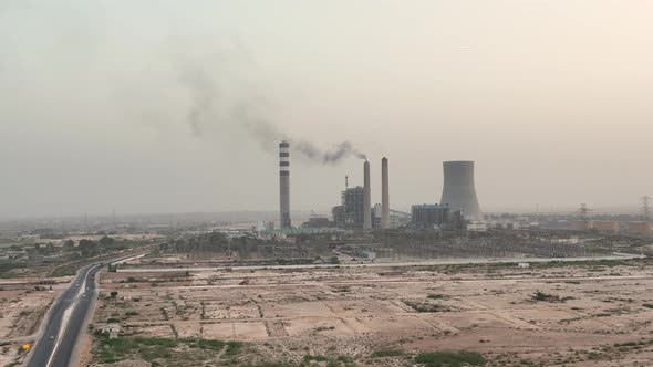 Aerial of factory in jamshoro Pakistan during sunset time. Drone around toxic enterprise chimneys tu