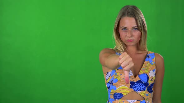 Young Pretty Blond Woman Disagrees (Show Thumb Down) - Green Screen - Studio