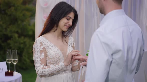 Portrait of Happy Young Middle Eastern Woman Putting Wedding Ring on Finger of Affectionate