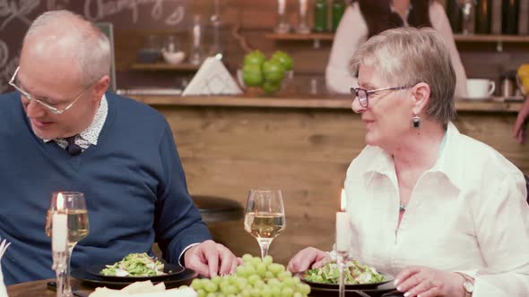 Old Man Offers Three Red Roses To His Wife on a Romantic Dinner