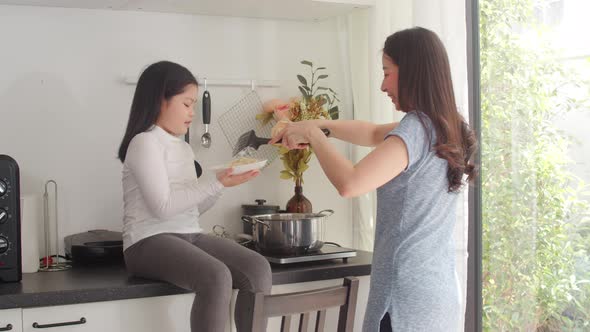 Lifestyle women happy making pasta and spaghetti together for breakfast meal in the kitchen