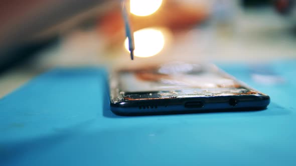 Close Up of a Mobile Phone Getting Carefully Dismantled