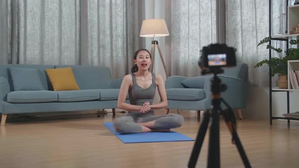 Trainer Female Waving Hand And Speaking To Camera While Recording Teaching Exercise At Home