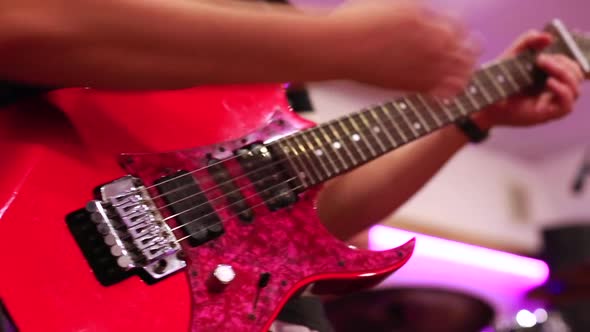 Close-up of Male Guitarist Hands Playing on Red Electric Guitar