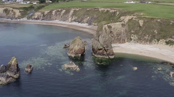 Eroded cliffs and rocky islets and shallow Celtic Sea water, pastures