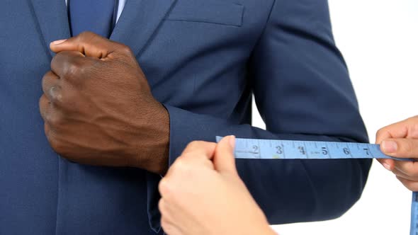Hands of fashion designer taking a measurement of businessman
