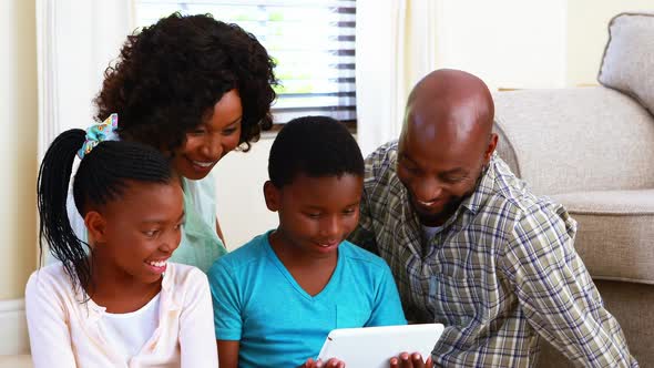 Family using digital tablet in living room 4k