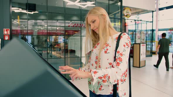 Woman Near Navigation Board in Mall