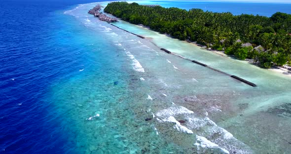 Wide birds eye travel shot of a summer white paradise sand beach and blue sea background in 4K