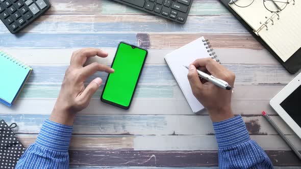 Top View of Man Hand Using Smart Phone on Office Desk 