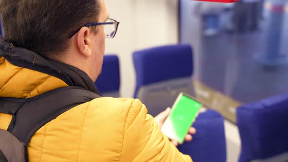 Blank Digital Phone in Hand of Guy Standing Indoors in Public Transport