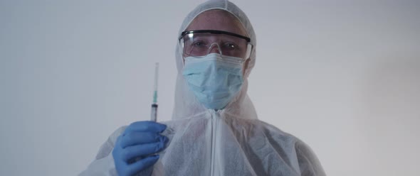 Woman in focus lifting an empty syringe opens cap