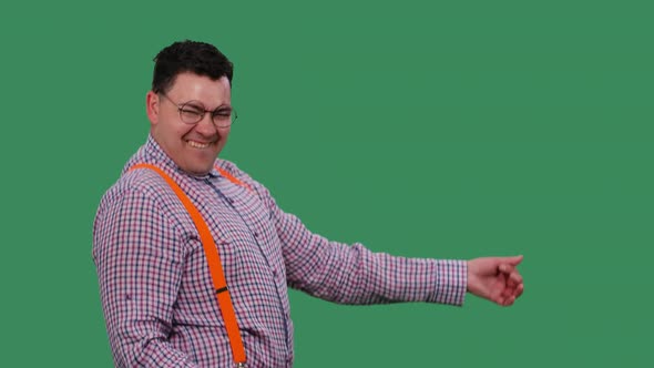 A Cheerful Man in Glasses Dances Imitating Playing the Guitar