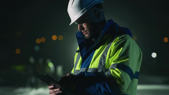 Serious Foreman Using Tablet at Night