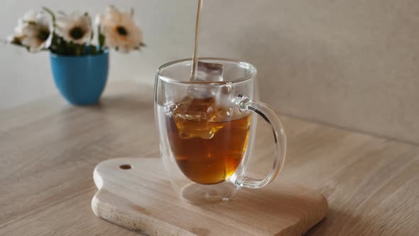 Pouring Coffee Tea Into a Cup with Ice