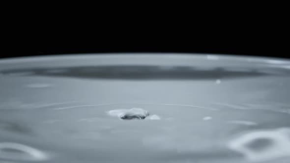 Water Drop Falls on the Water Surface in Slow Motion Macro Shot