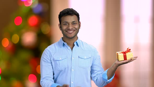 Smiling Man Showing Gift Box in His Palm