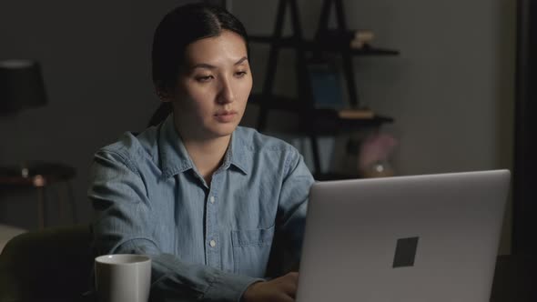 Front View Of Young Asoan Woman Working On Laptop In A Comfortable Home. Business woman 