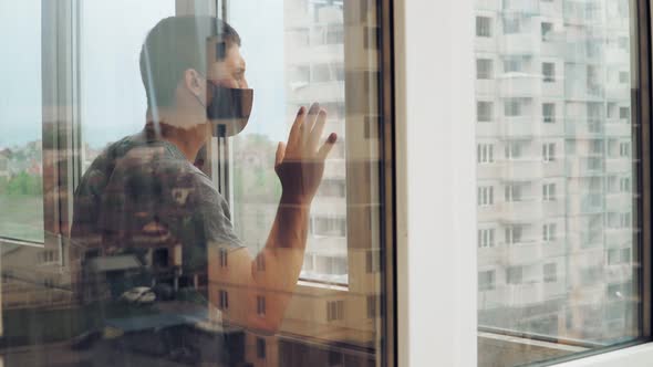 guy medical mask closed window during quarantine isolation home due coronavirus