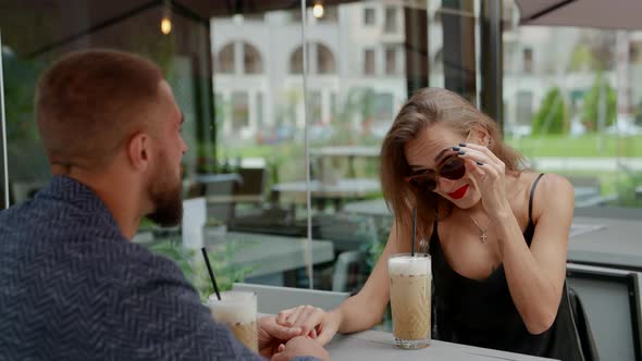 a Couple is Sitting at a Table in an Outdoor Cafe