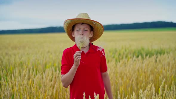 Teenager in straw hat on wheat field