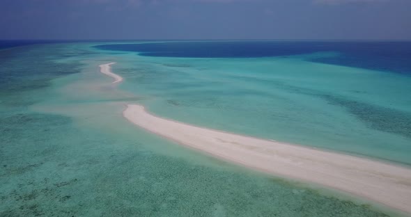 Natural birds eye island view of a white paradise beach and aqua blue ocean background in vibrant 4K