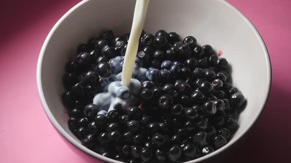 Pouring Milk on Fresh Blueberries