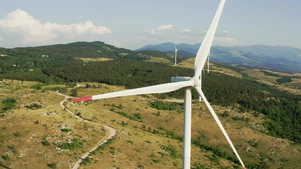 Camera Turns Around of a Spinning Wind Turbine in the Mountains