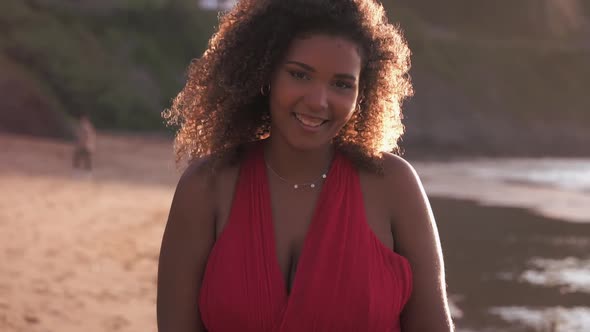 Beautiful young woman laughing happily on the beach