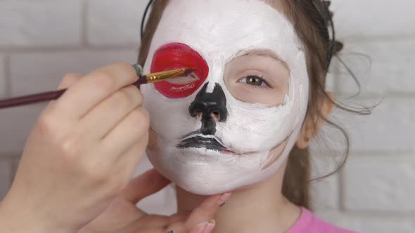 Beautiful little girl on Halloween make face art. alt