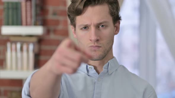 Portrait of Young Man Pointing Finger at Camera