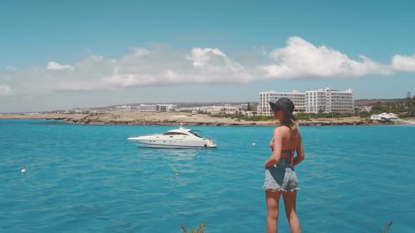 Female Travel Blogger Relax on Coast Watch Yacht Sail in Blue Water in Ayia Napa in Cyprus